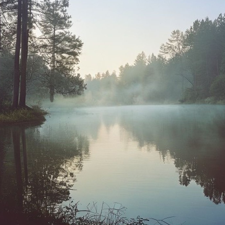 A calm lake at dawn, with mist rising from the water's surfa... | ShopAyahuascaRetreats
